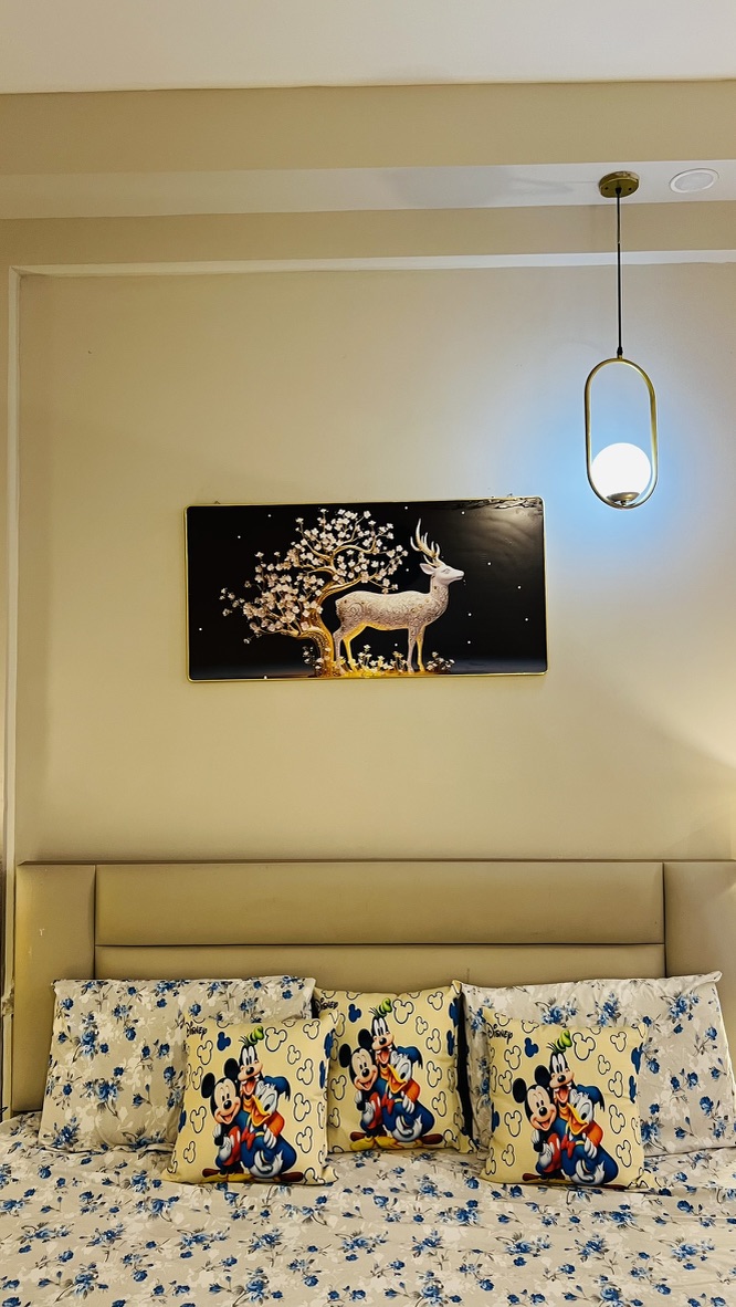 Bedroom headboard with gold art and pendant light